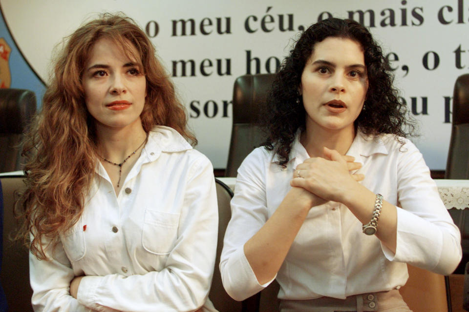 Former Mexican pop star Gloria Trevi (L) listens as her backup singer Maria Raquenel Portillo speaks during a news conference at Federal Police headquarters in Brasilia December 5, 2000. Teary-eyed and desperate, the fallen pop star made an impashioned plea to human rights groups to help her prove her innocence from sexual abuse charges just days ahead of her extradition hearing in Brazil.

JB