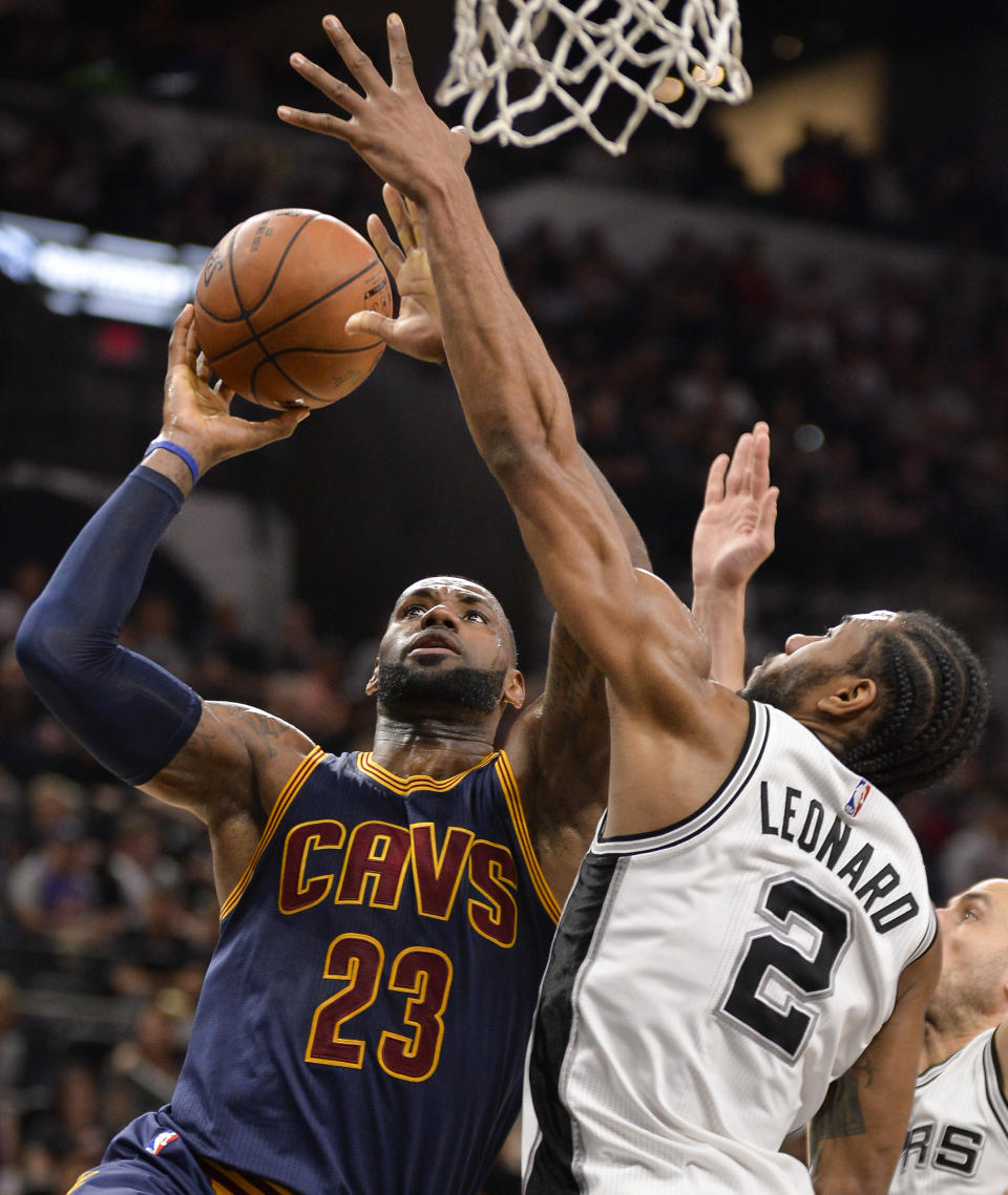 Cleveland Cavaliers forward LeBron James (23) shoots against San Antonio Spurs forward Kawhi Leonard during the first half of an NBA basketball game, Monday, March 27, 2017, in San Antonio. (AP Photo/Darren Abate)