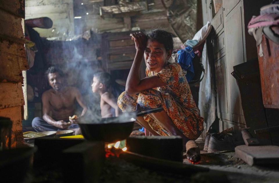 A woman sits by the fireplace at meal time in a shanty in Colombo, Sri Lanka, Wednesday, Oct. 5, 2022. International creditors should provide debt relief to Sri Lanka to alleviate suffering as its people endure hunger, worsening poverty and shortages of basic supplies, Amnesty International said in a statement Wednesday. (AP Photo/Eranga Jayawardena)