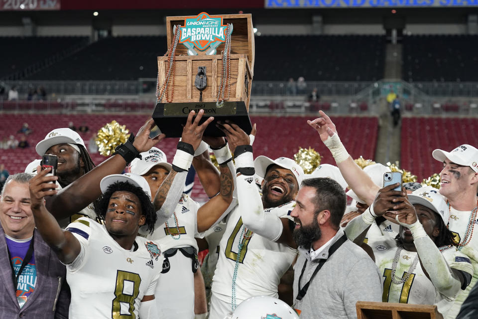 Georgia Tech players hold up the trophy after the team defeated Central Florida during the Gasparilla Bowl NCAA college football game Friday, Dec. 22, 2023, in Tampa, Fla. (AP Photo/Chris O'Meara)