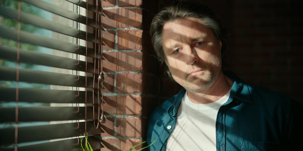  Jack Sheridan standing in front of some blinds as the shadow reflects onto him. 