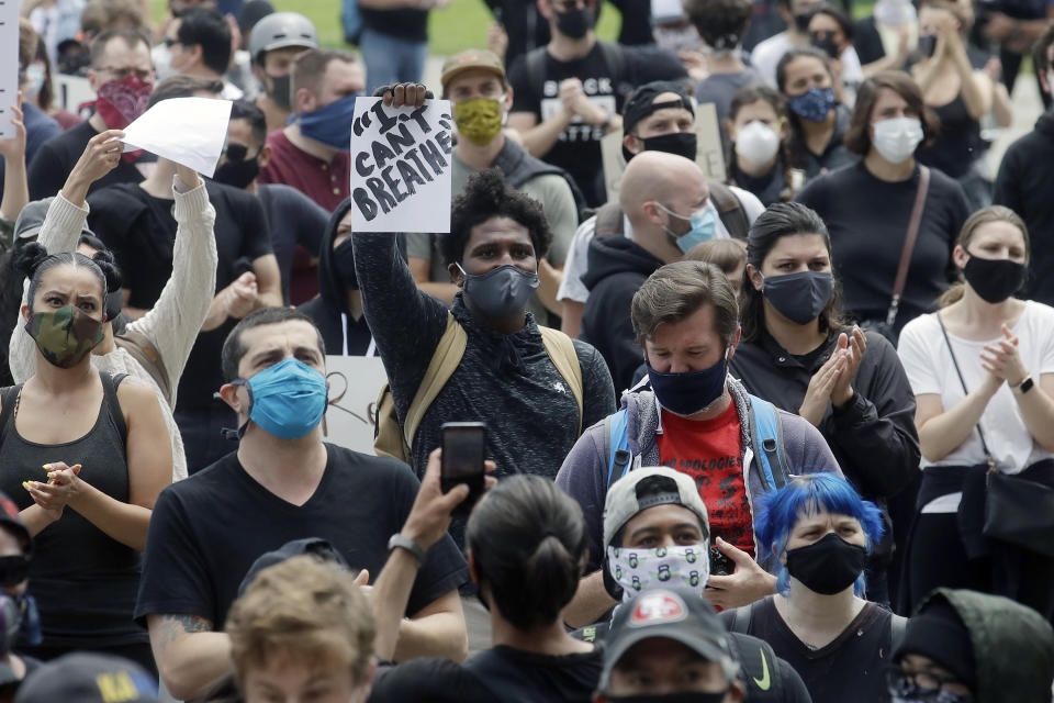 A man holds up a sign while listening to speakers at a protest over the Memorial Day death of George Floyd, a handcuffed black man in police custody in Minneapolis, in San Francisco, Saturday, May 30, 2020. (AP Photo/Jeff Chiu)