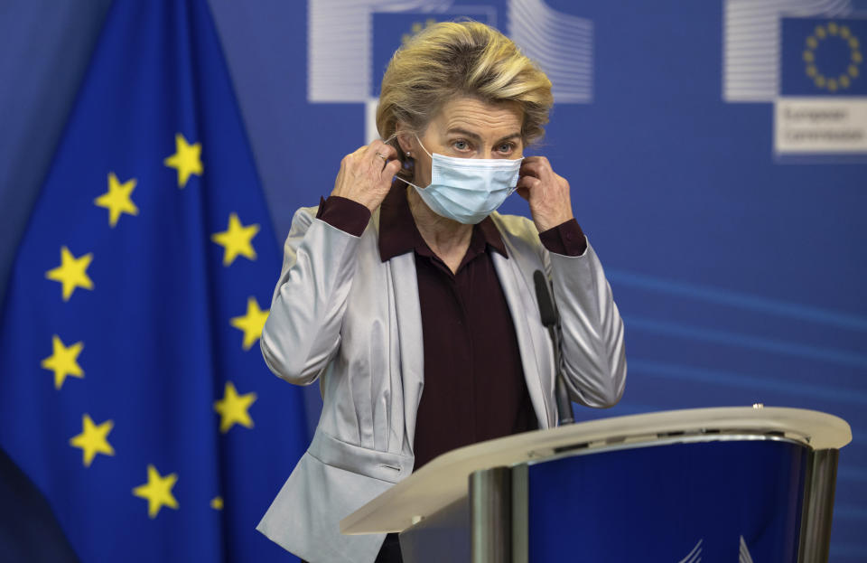 European Commission President Ursula von der Leyen takes off her protective face mask as she prepares to deliver a statement at EU headquarters in Brussels, Tuesday, Nov. 24, 2020. The European Commission announced on Tuesday that it has approved a new contract to secure another COVID-19 vaccine for Europeans. (AP Photo/Olivier Matthys, Pool)