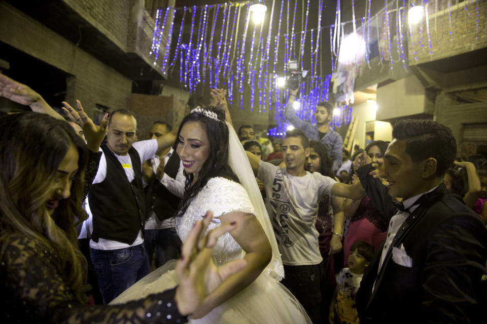 In this June 15, 2019 photo, an Egyptian couple dances with their families during a street party following their wedding ceremony, in the predominantly Christian Manshiyat Nasser area of Cairo. Egypt’s legal system grants the Coptic church full authority over personal status matters of Copts, namely marriage and divorce. But the church does not have the same powers over its followers’ inheritance rights. (AP Photo/Maya Alleruzzo)