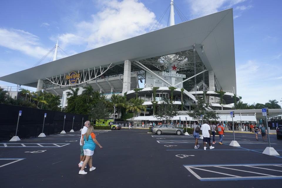 Football fans arrive at Hard Rock Stadium before a NFL preseason football game between the Miami Dolphins and the Philadelphia Eagles, Saturday, Aug. 27, 2022, in Miami Gardens, Fla. (AP Photo/Wilfredo Lee)