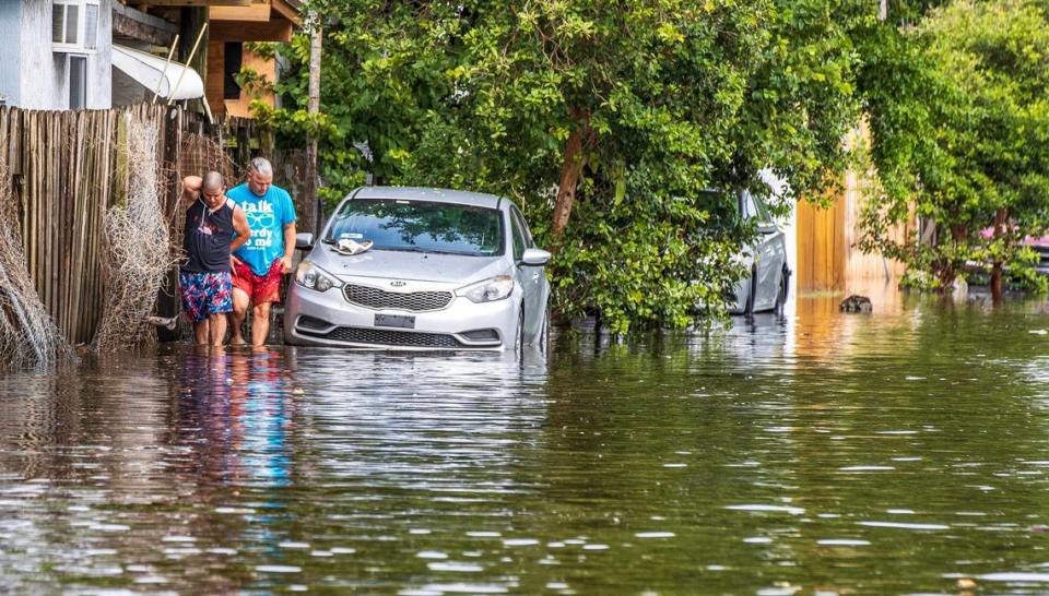 Two men walk through the flood at West 14th Avenue and West 29th Street in Hialeah as torrential downpours inundate South Florida due to a disturbance off Florida’s coast on Thursday, November 16, 2023. Pedro Portal/pportal@miamiherald.com