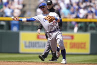 Chicago Cubs shortstop Nico Hoerner throws to first base to put out Colorado Rockies' Brendan Rodgers in the second inning of a baseball game, Sunday, April 17, 2022, in Denver. (AP Photo/David Zalubowski)