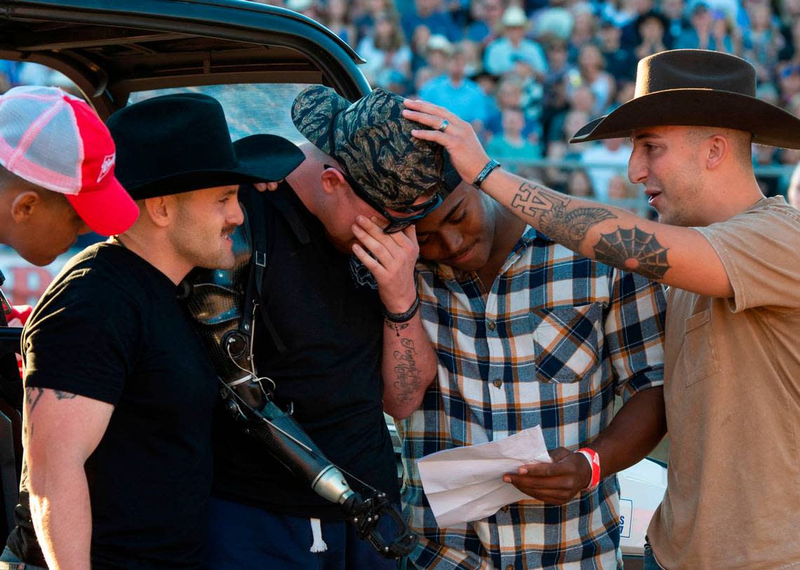 U.S. Marine Sergeant Tyler Vargas-Andrews, center, is consoled his Marine Corps “Brothers in Arms” Daulton Hannigan, Caden Cooper, and Jorge Mayo, who served in his unit in Kabul, as he’s moved to tears during a ceremony at the Folsom Pro Rodeo on Sunday.