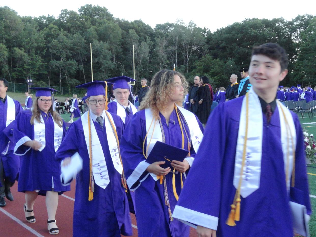 Alumni of Wallenpaupack Area High School Class of 2022 march from the football field.