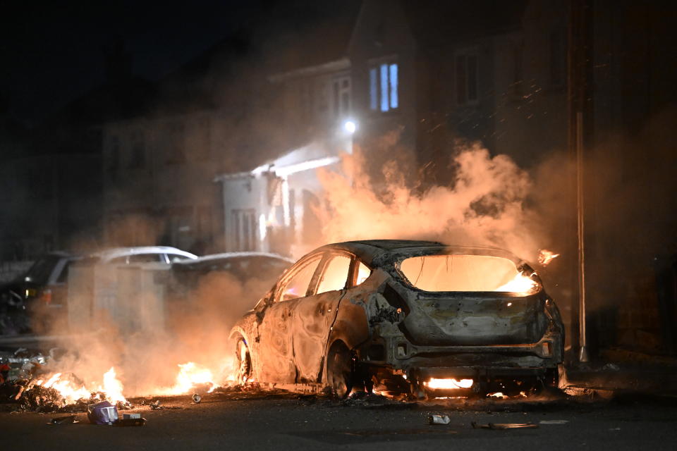 CARDIFF, WALES - MAY 23: An automobile burns on Highmead Road during unrest following a serious road crash earlier on Snowden Road on May 23, 2023 in Cardiff, Wales. Riot Police with dogs are trying to contain a large group of people causing serious disorder in Ely, Cardiff tonight. Fires have been started and missiles thrown at police after they attended a serious road traffic collision earlier in the evening. (Photo by Matthew Horwood/Getty Images)