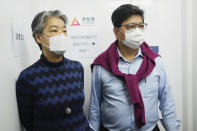 Chris Yeung, right, founder and chief writer, and Daisy Li, chief editor of Citizen News, stand outside their office before a news conference in Hong Kong, Monday, Jan. 3, 2022. The Hong Kong online news site said Sunday that it will cease operations in light of deteriorating press freedoms, days after police raided and arrested several people for sedition at a separate pro-democracy news outlet. (AP Photo/Vincent Yu)