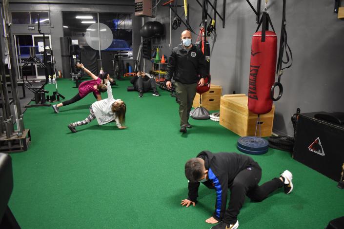 Parents and children take part in a family fitness class instructed by Omar Munguya at O.M.R Performance gym in Salinas, Calif.