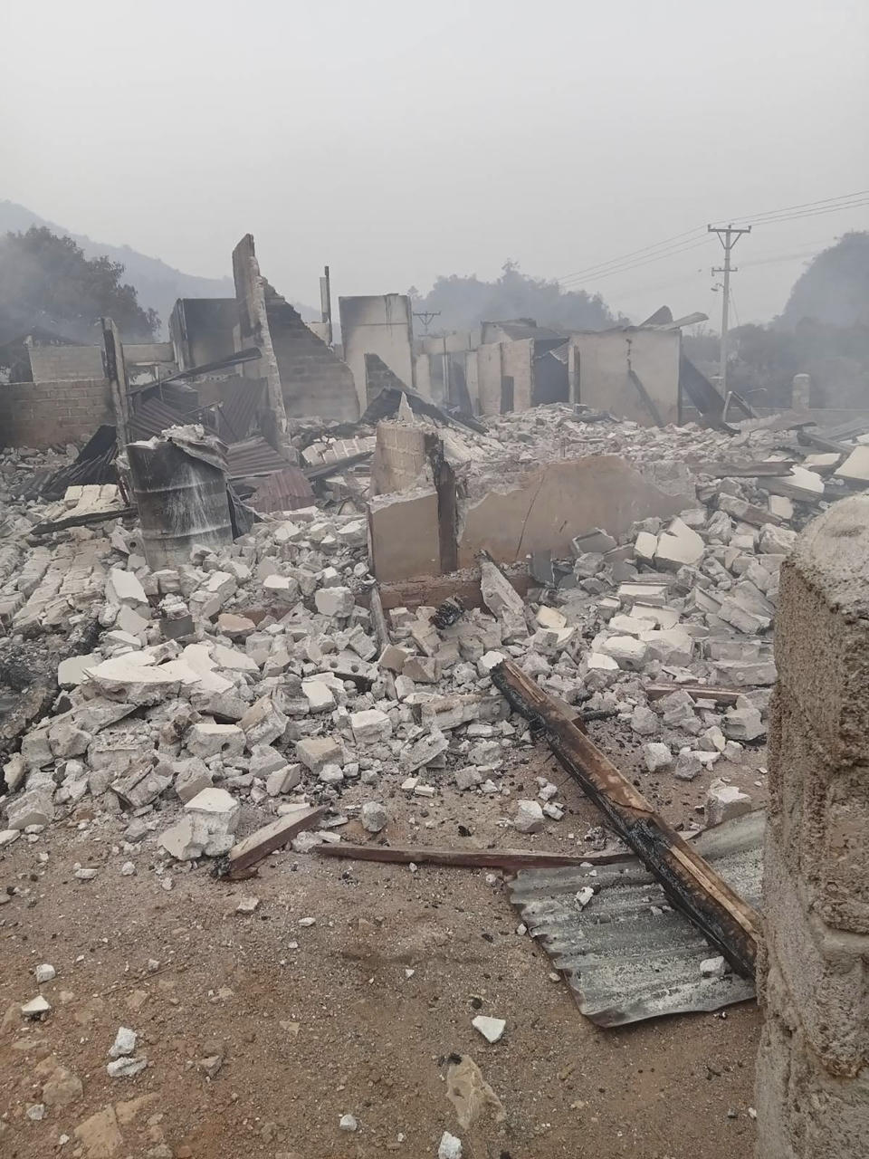 In this image provided by the Karenni Nationalities Defense Force, debris from destroyed concrete structures are scattered in Nam Nein village, Pinlaung township in Shan state, Myanmar on Sunday, March 12, 2023. Myanmar's military government has denied reports of a new mass killing of civilians by its troops, instead blaming pro-democracy resistance groups for the deaths of more than 20 people. (Karenni Nationalities Defense Force via AP)