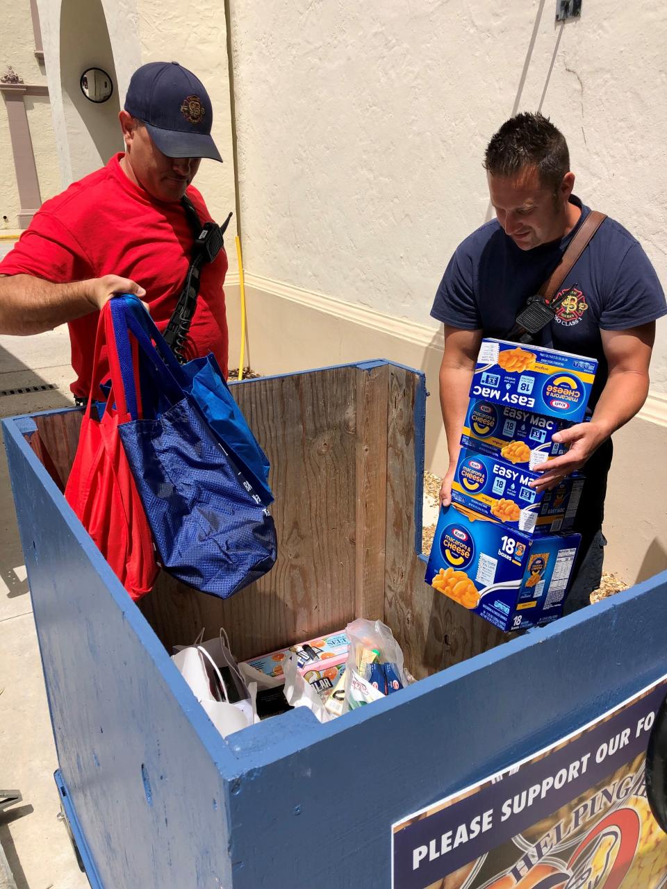 Palm Beach Fire Rescue firefighter Robert Richardson and Lt. Mike Messner load donations recently from the Empty Your Pantry Food Drive.