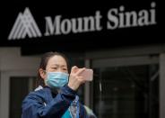 A healthcare worker uses her phone outside at Mount Sinai Hospital hold a protest demanding critical Personal Protective Equipment (PPE) to handle patients during the outbreak coronavirus disease (COVID-19) outbreak, in New York