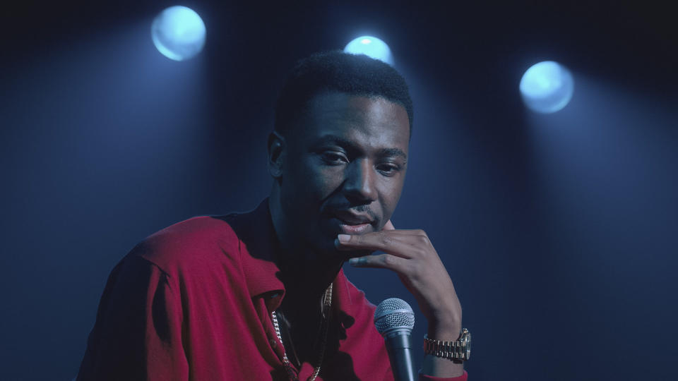 a man onstage talking into a mic