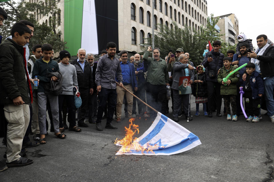Iranian worshippers burn a representation of the Israeli flag during their pro-Palestinian rally before the Friday prayers in Tehran, Iran, Friday, Oct. 13, 2023. (AP Photo)