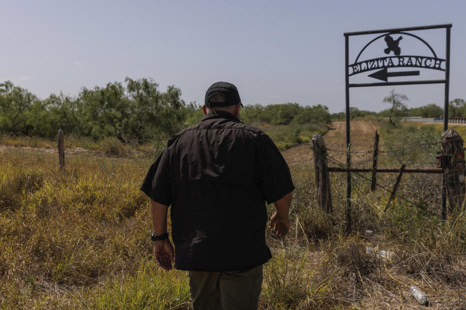 Jim Hogg County Sheriff's Investigator Ruben Garza at the location of a missing water station for immigrants containing sealed jugs of fresh water along a fence line near a roadway in rural Jim Hogg County, Texas, Tuesday, July 25, 2023. The South Texas Human Rights Center maintains over 100 blue barrels consistently stocked with water across rural South Texas to serve as a life-saving measure for immigrants who have crossed into the United States to travel north in the sweltering heat. (AP Photo/Michael Gonzalez)