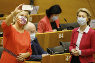 An MEP takes a mobile phone photo of European Commission President Ursula von der Leyen, right, prior to her address to the European Parliament plenary in Brussels, Wednesday, May 27, 2020. The European Union is to unveil Wednesday a massive coronavirus recovery plan worth hundreds of billions of euros to help countries rebuild their ailing economies, but the bloc remains deeply divided over what conditions should be attached to the funds. (AP Photo/Olivier Matthys)