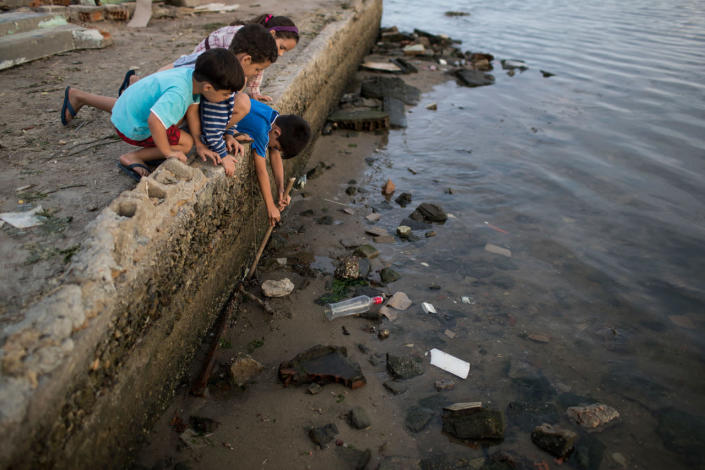 <p>Children try to catch a crab as they play on the polluted shore of Guanabara Bay in Rio de Janeiro, Brazil, Saturday, July 30, 2016. In Rio, the main tourist gateway to the country, a centuries-long sewage problem that was part of Brazil’s colonial legacy has spiked in recent decades in tandem with the rural exodus that saw the metropolitan area nearly double in size since 1970. (AP Photo/Felipe Dana)
