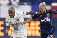 LA Galaxy defender Julian Araujo, left, hits Seattle Sounders midfielder Kelyn Rowe in the face as they battle for the ball during the first half of a Major League Soccer match Saturday, June 19, 2021, in Carson, Calif. (AP Photo/Mark J. Terrill)