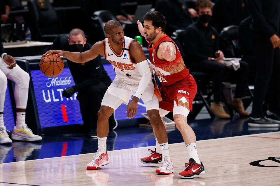 Phoenix Suns guard Chris Paul controls the ball against Denver Nuggets guard Facundo Campazzo.