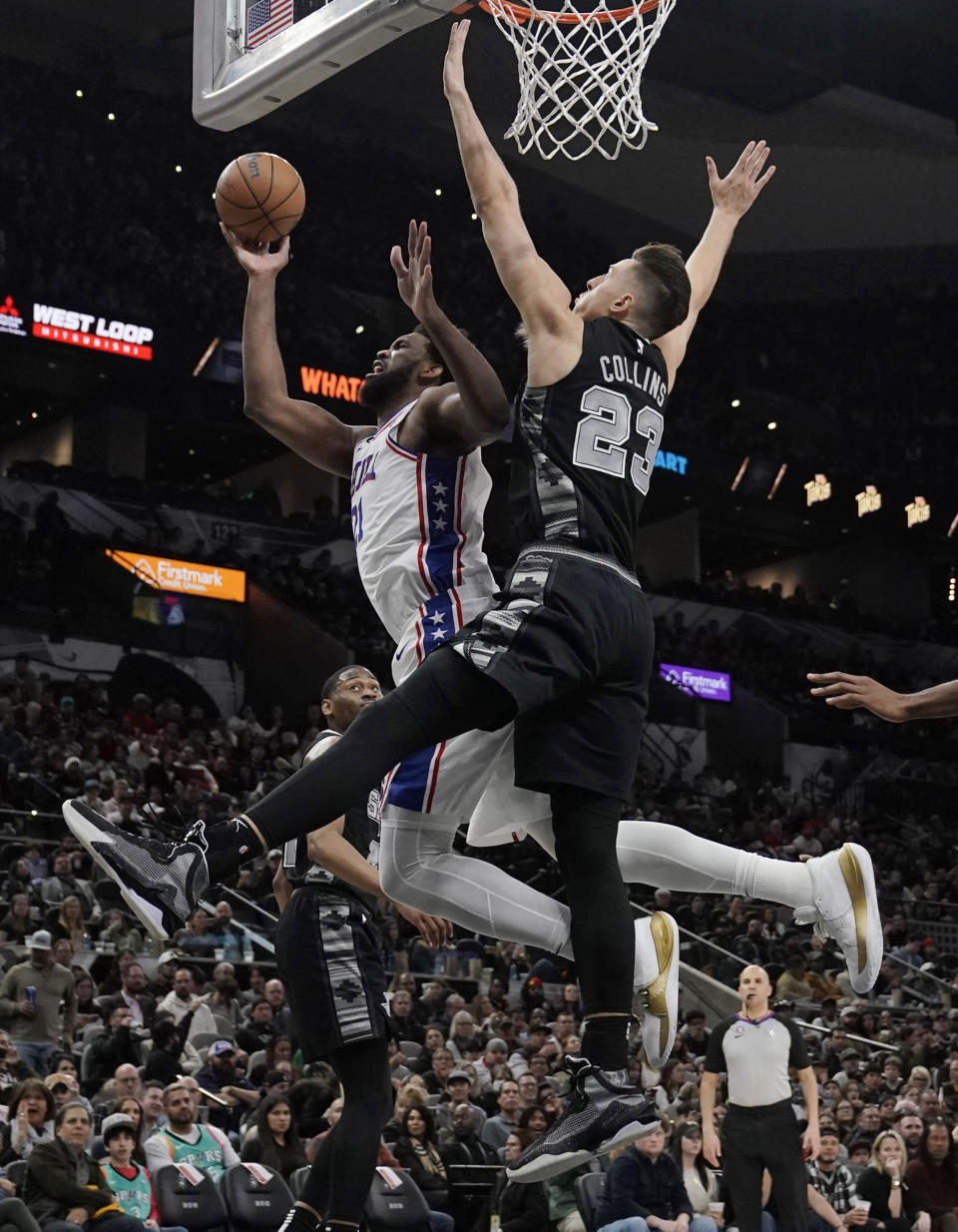 Philadelphia 76ers center Joel Embiid (21) is fouled as he drives to the basket against San Antonio Spurs forward Zach Collins (23) during the first half of an NBA basketball game in San Antonio, Friday, Feb. 3, 2023. (AP Photo/Eric Gay)