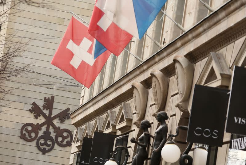 FILE PHOTO: A logo of Swiss bank UBS is seen next to a Swiss flag in Zurich