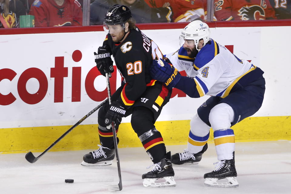 Calgary Flames' Blake Coleman, left, protects the puck from St. Louis Blues' Nick Leddy during second-period NHL hockey game action in Calgary, Alberta, Friday, Dec. 16, 2022. (Larry MacDougal/The Canadian Press via AP)