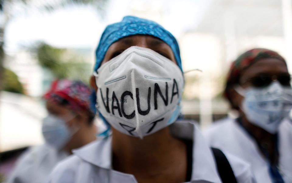 Venezuelan health workers pictured during a protest against the government over a lack of available vaccines - Reuters