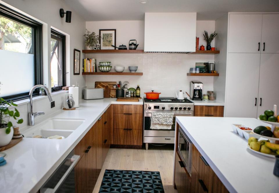 A kitchen with wood cabinets and white countertops