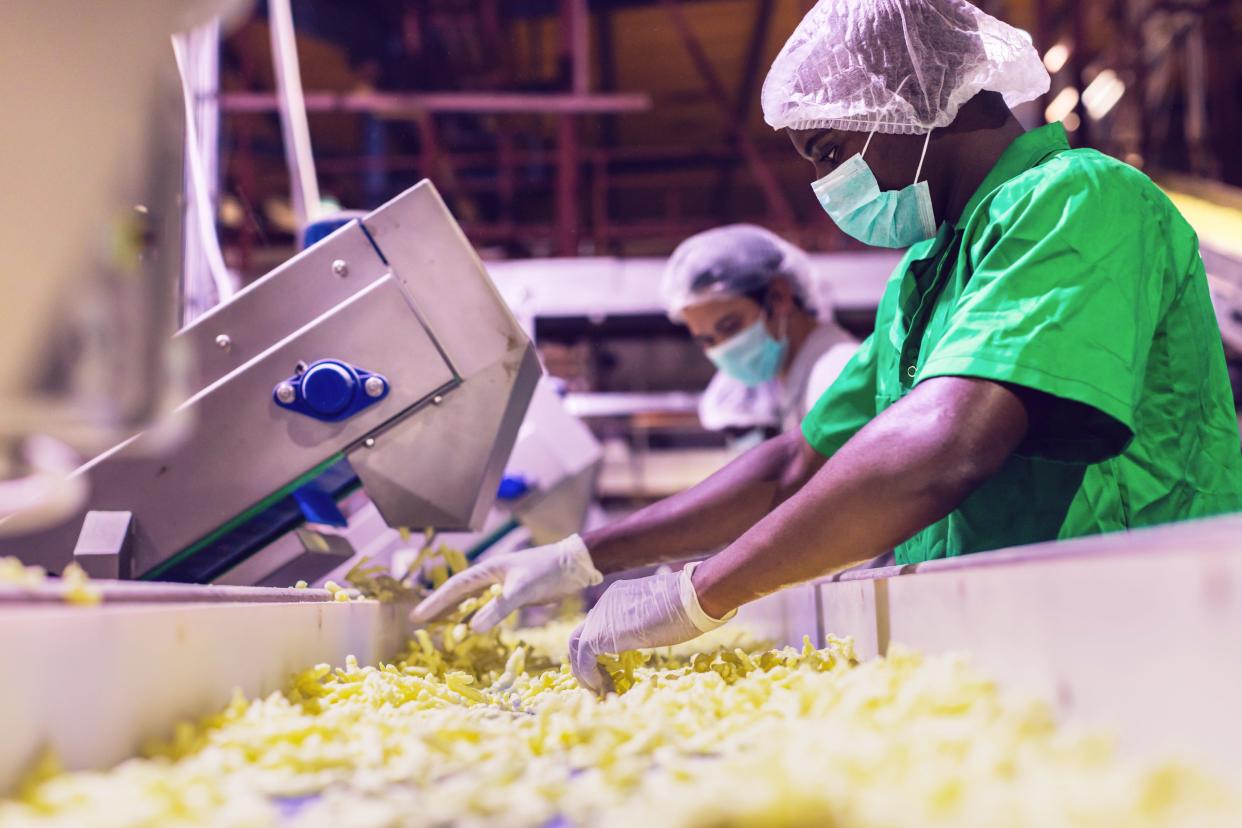 Workers checking food quality on an assembly line.