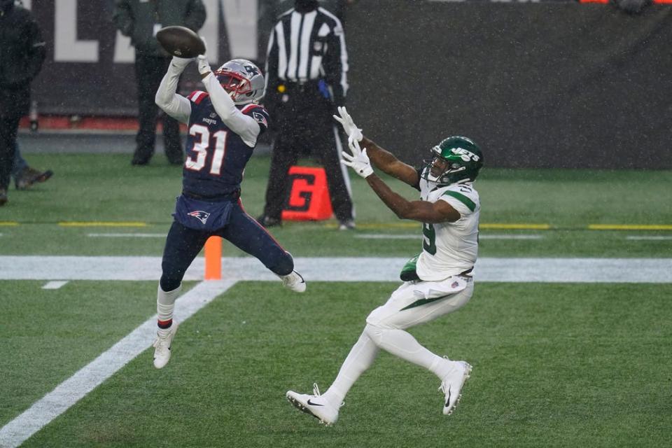 New England Patriots defensive back Jonathan Jones, left intercepts a pass in the end zone intended for New York Jets wide receiver Breshad Perriman, right, in the second half of an NFL football game, Sunday, Jan. 3, 2021, in Foxborough, Mass. (AP Photo/Elise Amendola) ORG XMIT: FBO136