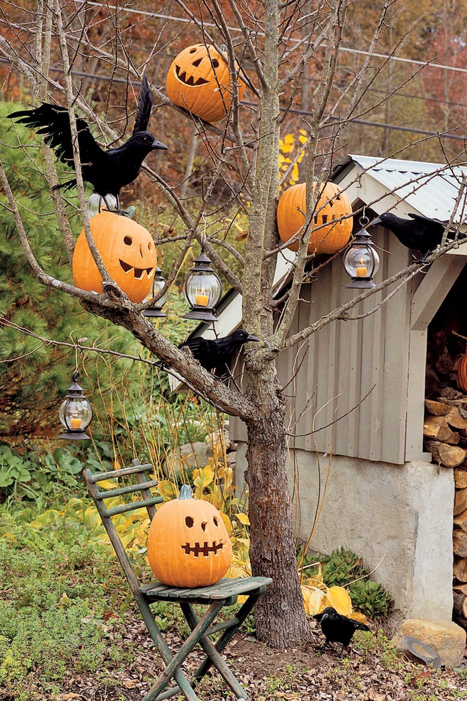 <p>Bare-limbed trees provide the perfect ghostly perch for jack-o'-lanterns, LED candle lanterns, and a flock of faux black crows. Make sure the tree limbs are sturdy enough to support the weight of the items you are hanging and take care not to over-decorate, which can lessen the overall effect. Funkins (Styrofoam pumpkins) are an especially good choice for this project, since they're lightweight and won't rot. </p>