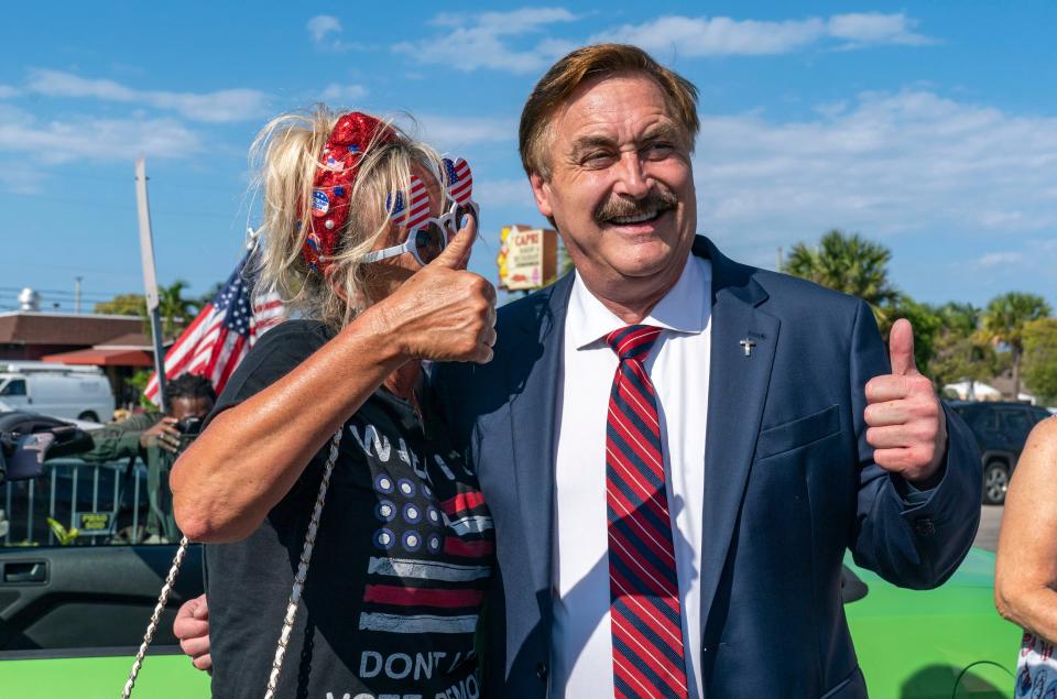 Mike Lindell, the My Pillow Inc chief executive poses withTrump supporters as they wait along the motorcade route for former President Donald Trump to  return home to Mar-a Lago following his arraignment in New York on April 4, 2023. 