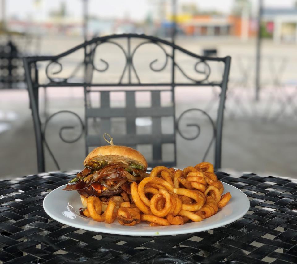 A burger with curly fries.