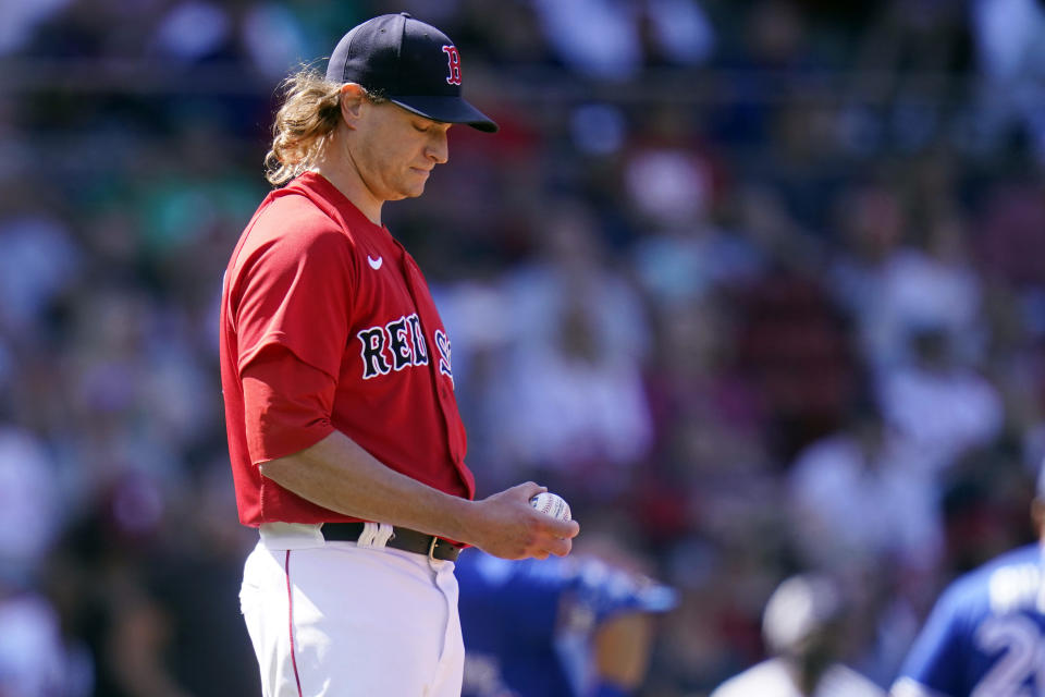 Boston Red Sox starting pitcher Garrett Richards looks down at a fresh baseball after giving up a two-run home run to Toronto Blue Jays' Randal Grichuk in the fourth inning of a baseball game at Fenway Park, Wednesday, July 28, 2021, in Boston. (AP Photo/Charles Krupa)