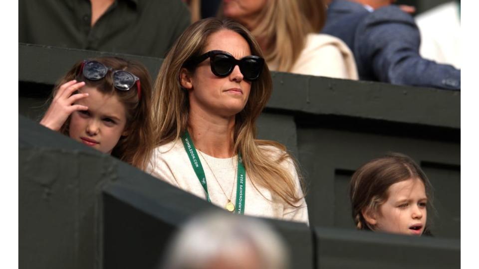 Kim Murray with two young girls watching tennis