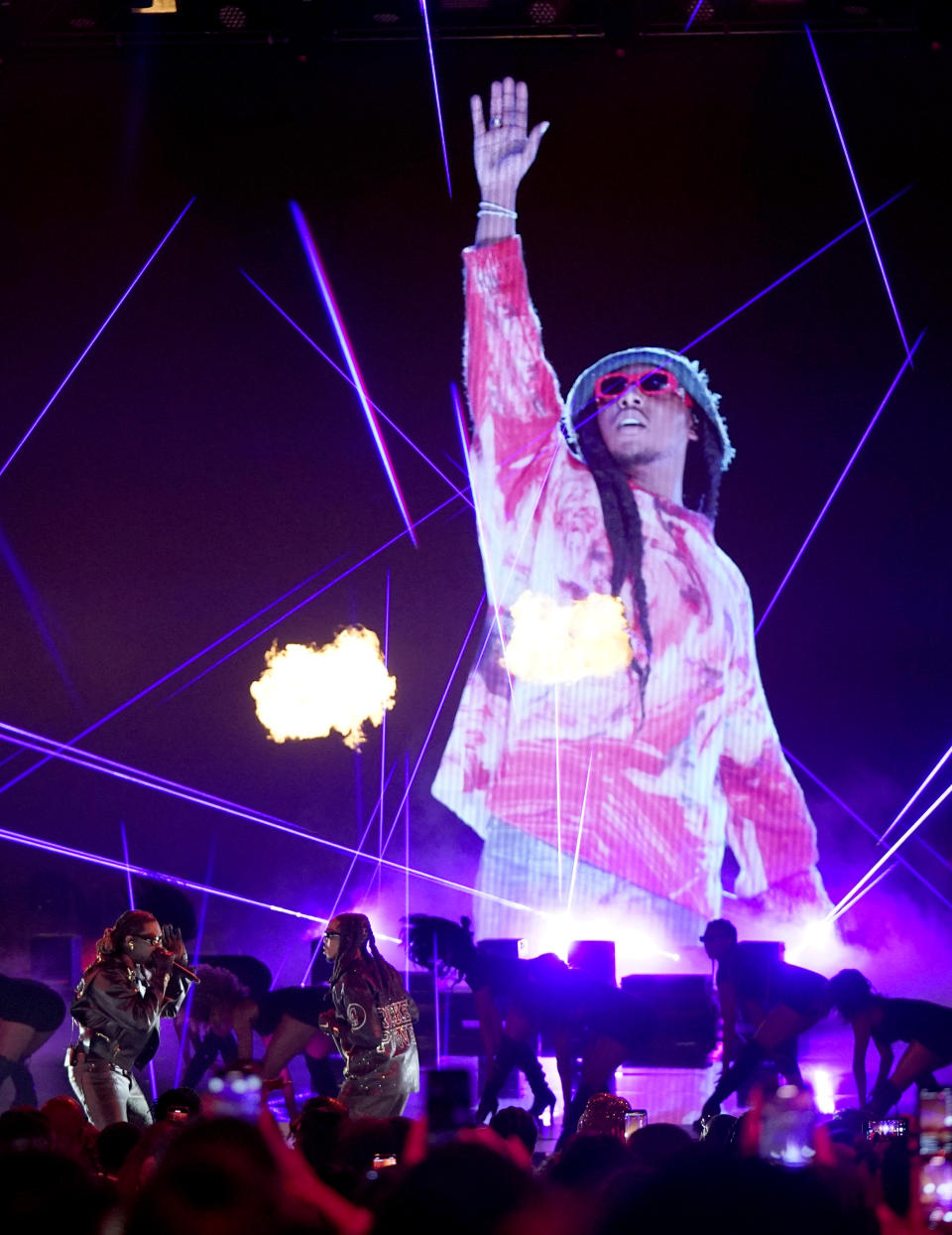 An image of Takeoff, the late member of Migos, appears on screen as his fellow group members Offset, left, and Quavo perform at the BET Awards on Sunday, June 25, 2023, at the Microsoft Theater in Los Angeles. (AP Photo/Mark Terrill)