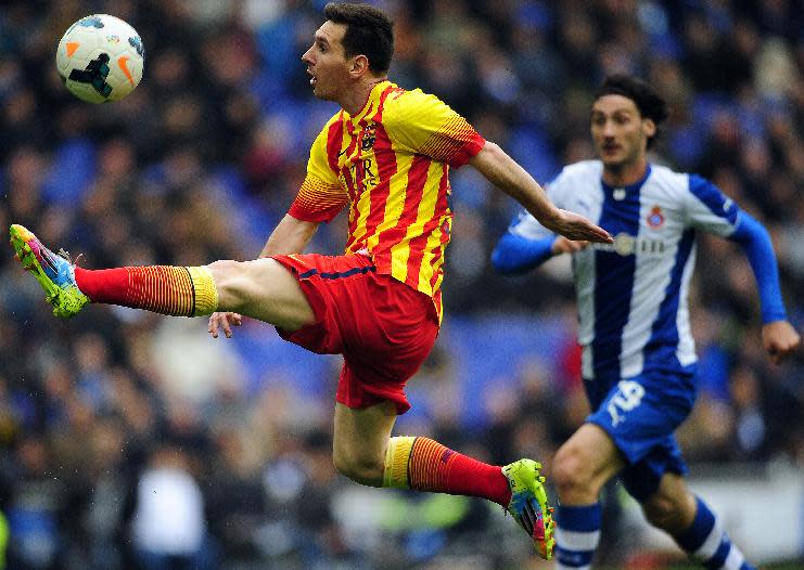 FC Barcelona's Lionel Messi, left, duels for the ball against Espanyol's Diego Colotto during a Spanish La Liga soccer match against Espanyol at Cornella-El Prat stadium in Cornella Llobregat, Spain, Saturday, March 29, 2014. (AP Photo/Manu Fernandez)