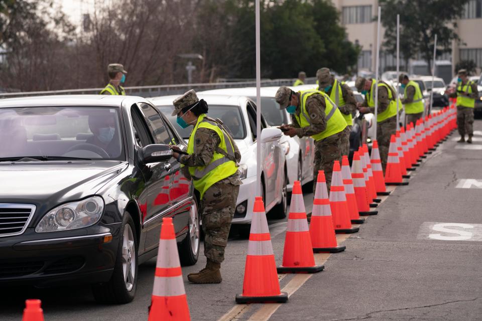 Members of the National Guard help motorists check in at a federally-run COVID-19 vaccination site set up on the campus of California State University of Los Angeles in mid-February.