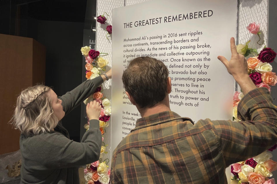 The story is scheduled to be released at 12:01 am ET Saturday. Here's a caption: Bess Goldy, left, helps arrange a display at the Muhammad Ali Center in Louisville, Ky., on Thursday, April 4, 2024. Goldy is curator of a new exhibit chronicling the outpouring of emotions in Ali's hometown following the boxing champion's death in 2016. (AP Photo/Bruce Schreiner)