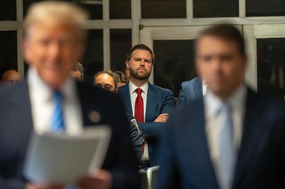 J.D. Vance listens as Donald Trump speaks to the media in the Manhattan courthouse where his hush-money trial is taking place.