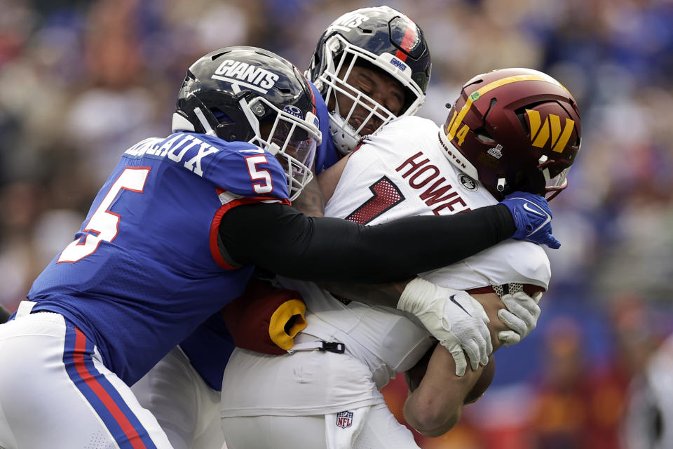 New York Giants linebacker Kayvon Thibodeaux (5) and defensive tackle Dexter Lawrence II (97) sack Washington Commanders quarterback Sam Howell (14) during the second quarter of an NFL football game, Sunday, Oct. 22, 2023, in East Rutherford, N.J. (AP Photo/Adam Hunger)