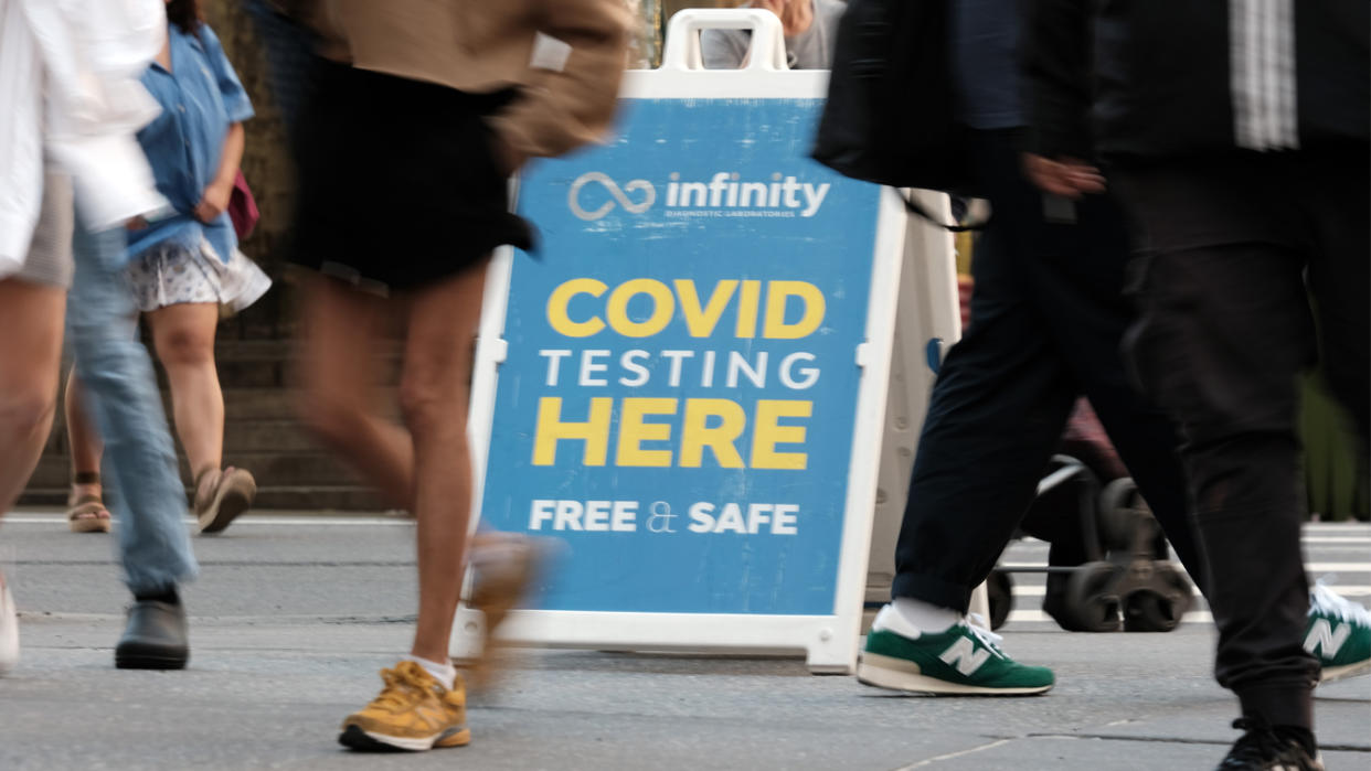 People walk past a COVID testing site on May 17, 2022, in New York City. 