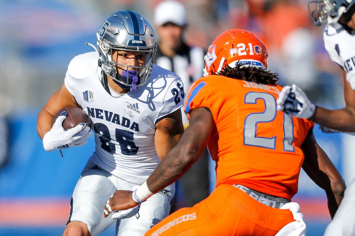 Nevada running back Avery Morrow (25) runs with the ball as Boise State safety Tyreque Jones (21) moves in for the tackle in the second half of an NCAA college football game Saturday, Oct. 2, 2021, in Boise, Idaho. Nevada won 41-31. (AP Photo/Steve Conner)