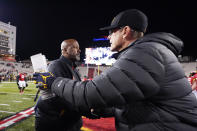 Maryland head coach Michael Locksley, left, shakes hands with Maryland head coach Michael Locksley after an NCAA college football game, Saturday, Nov. 20, 2021, in College Park, Md. Michigan won 59-18. (AP Photo/Julio Cortez)