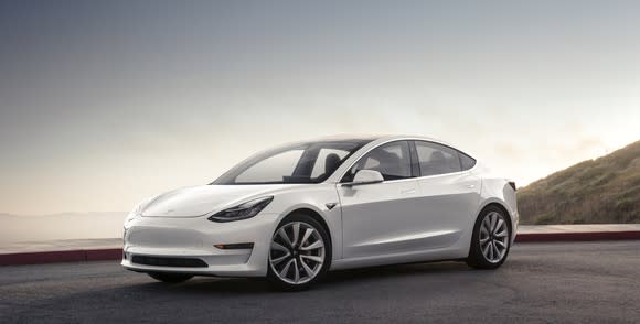 A white Tesla Model 3, an upscale electric luxury sports sedan.