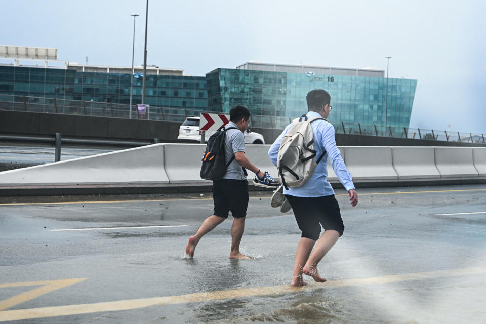 Pedestrians cross a flooded street (Anadolu via Getty Images)