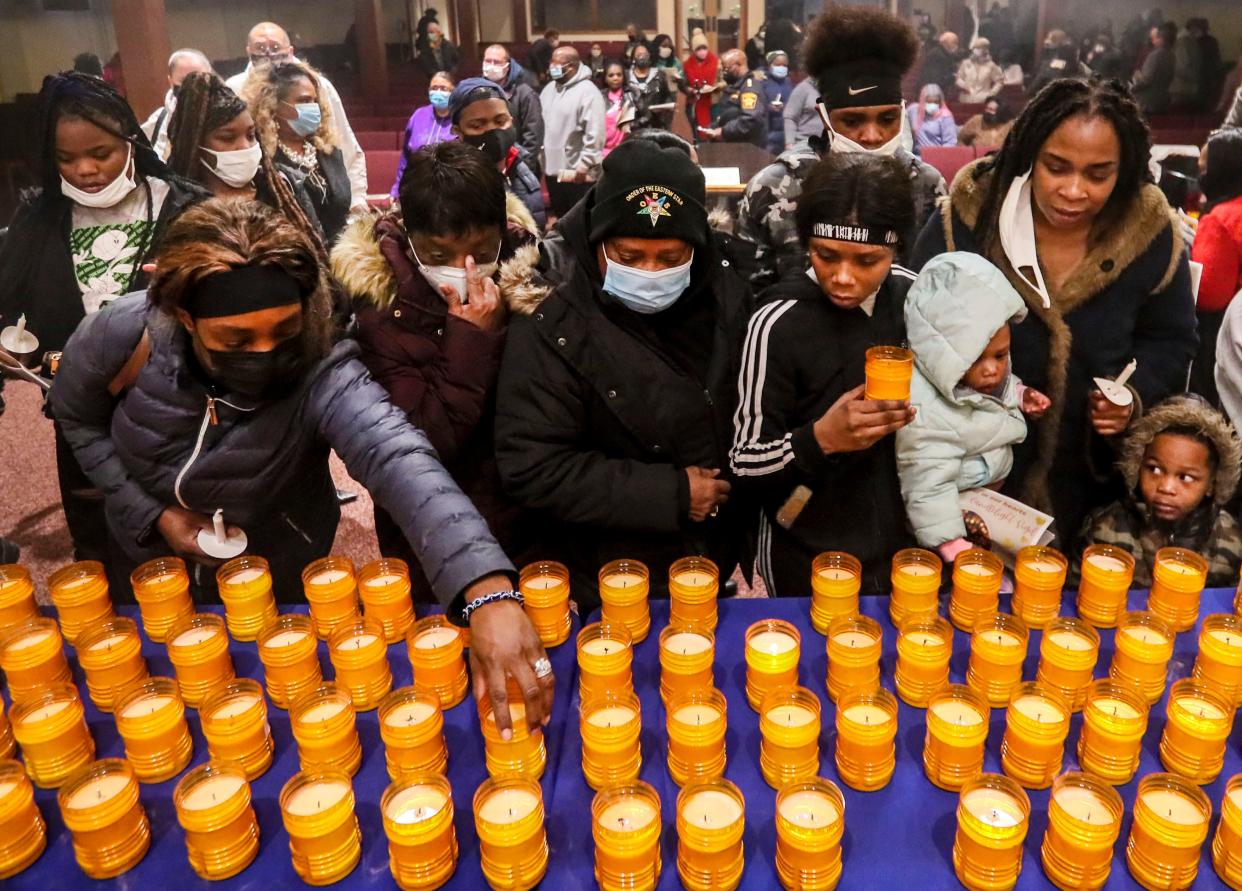 Family and friends of homicide victims gather to grab their loved ones' candles Thursday after a candlelight vigil for 2021 homicide victims at Ephesians Missionary Baptist Church in Milwaukee.